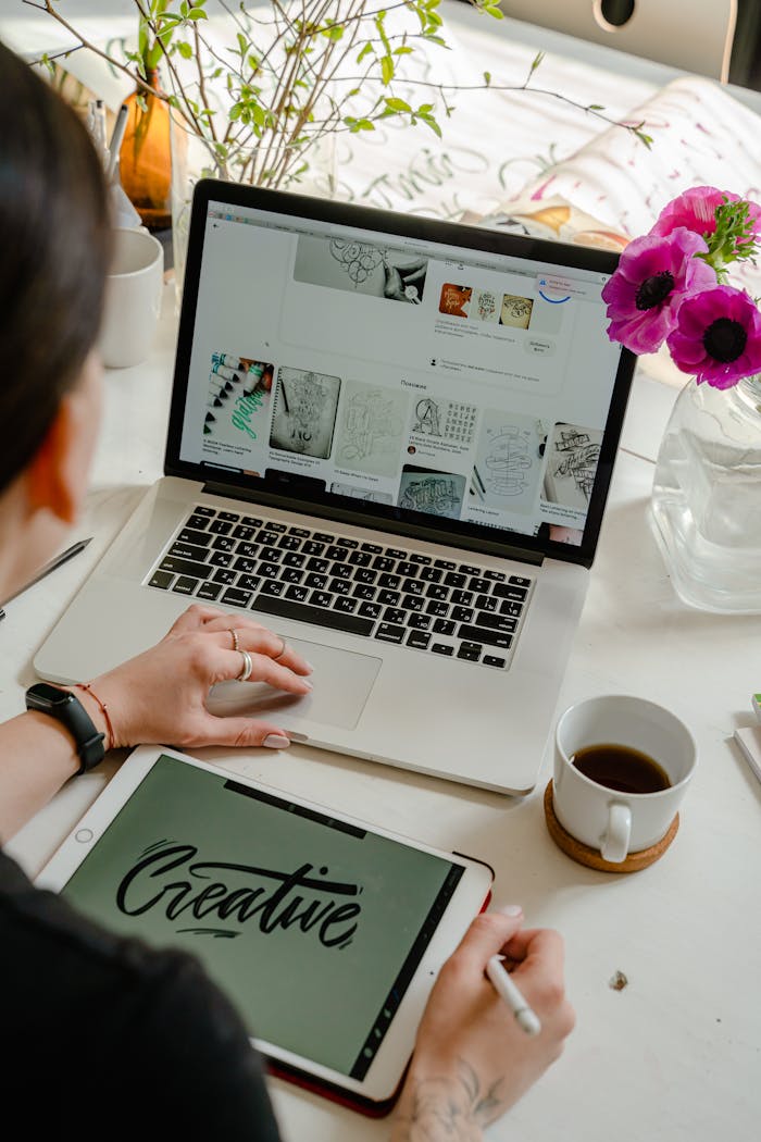 our-stories Creative work session featuring a woman using a tablet and laptop for design projects.